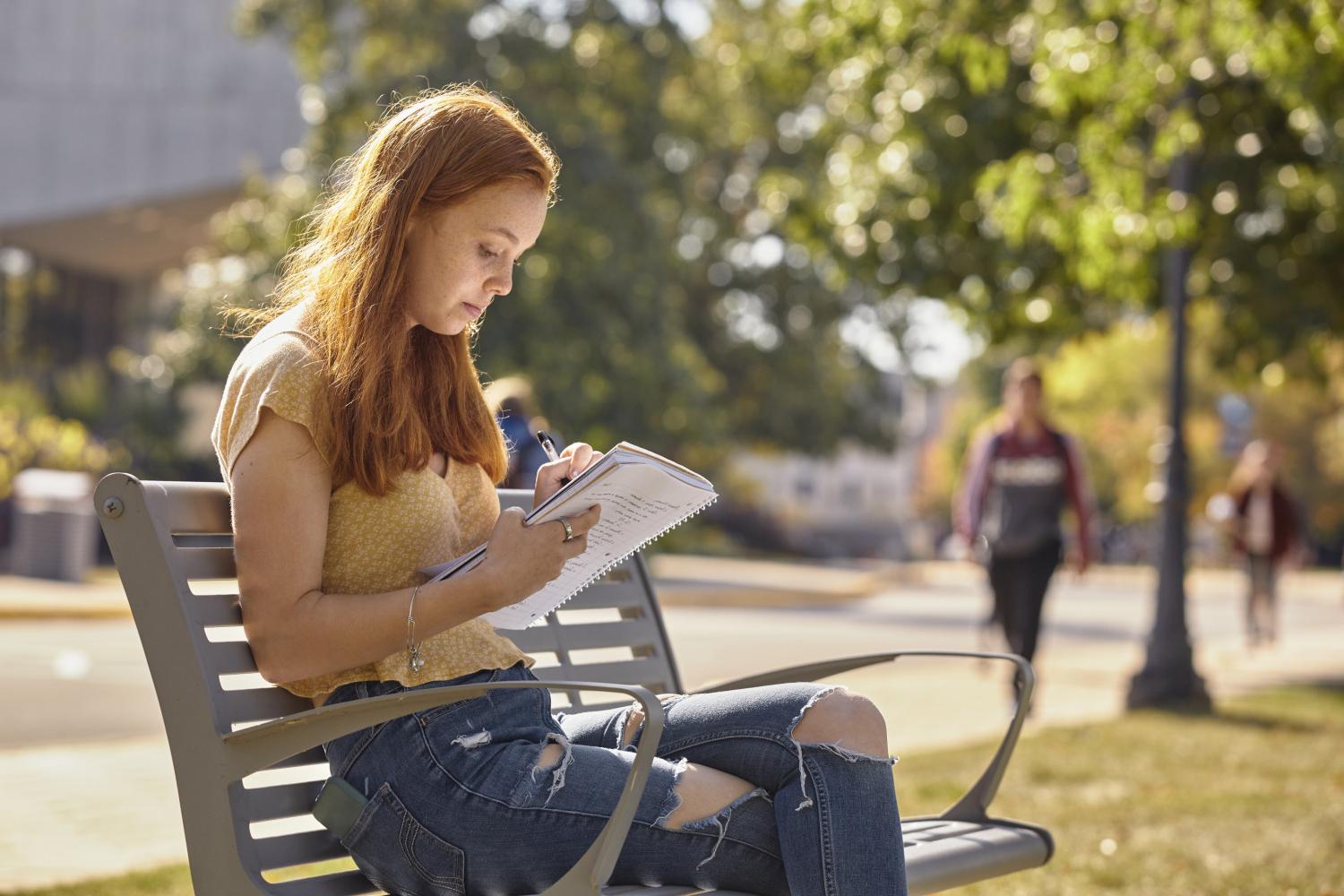 一位<a href='http://zuec.ngskmc-eis.net'>全球十大赌钱排行app</a>学院的学生在校园里的长椅上读书.